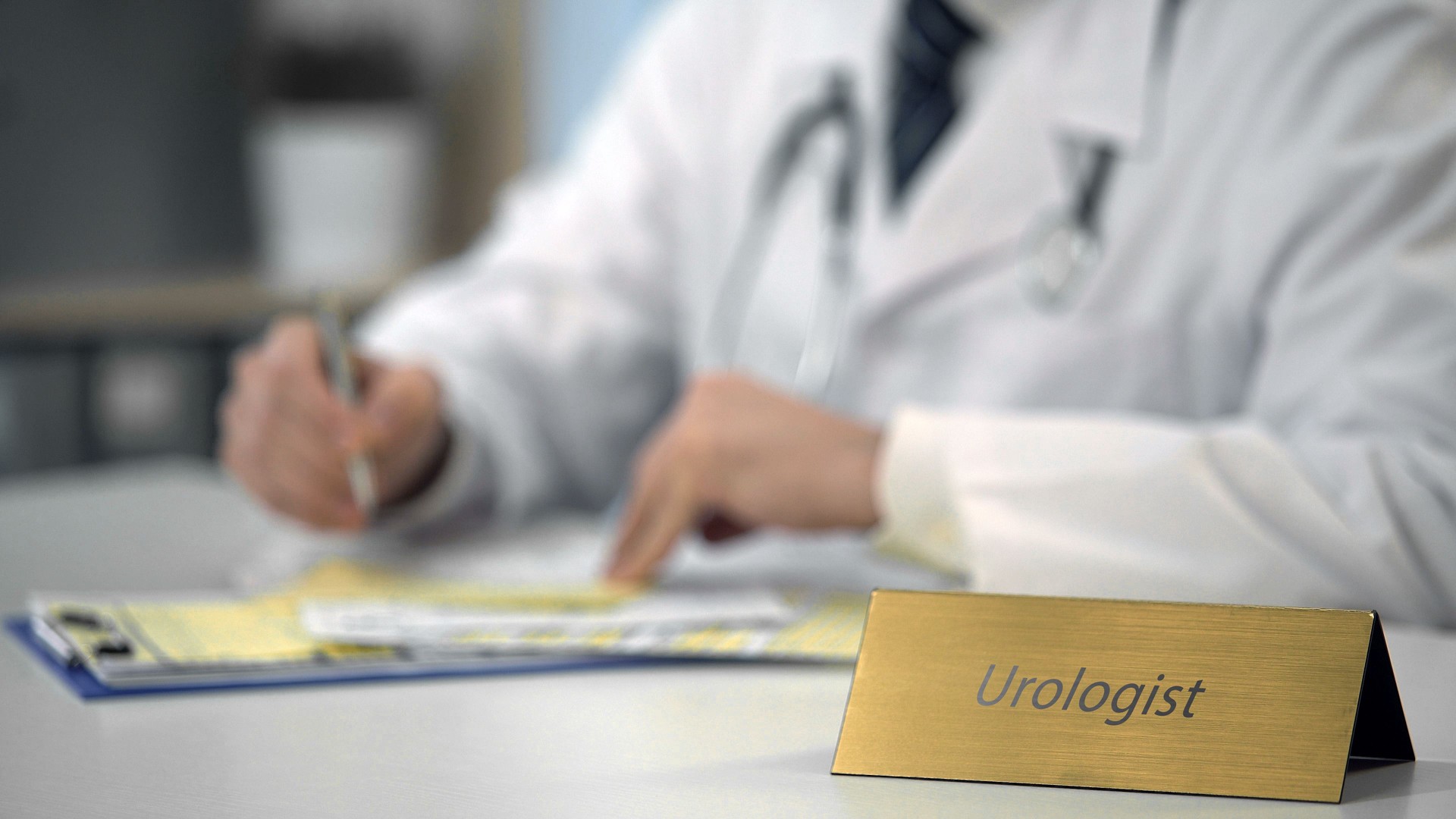 Urologist consulting patients online using laptop, typing monthly report, health